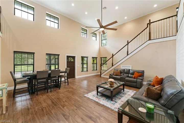 Living area with ornamental molding, wood finished floors, healthy amount of natural light, recessed lighting, and ceiling fan