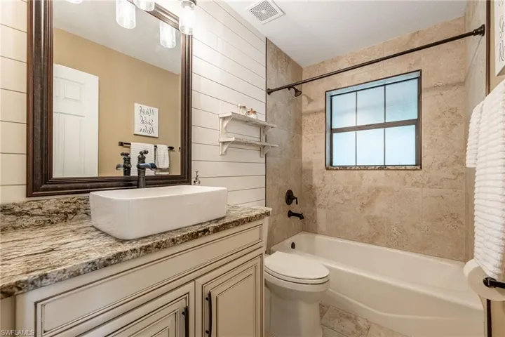 Bathroom with shower / bathtub combination, vanity, and tile patterned flooring