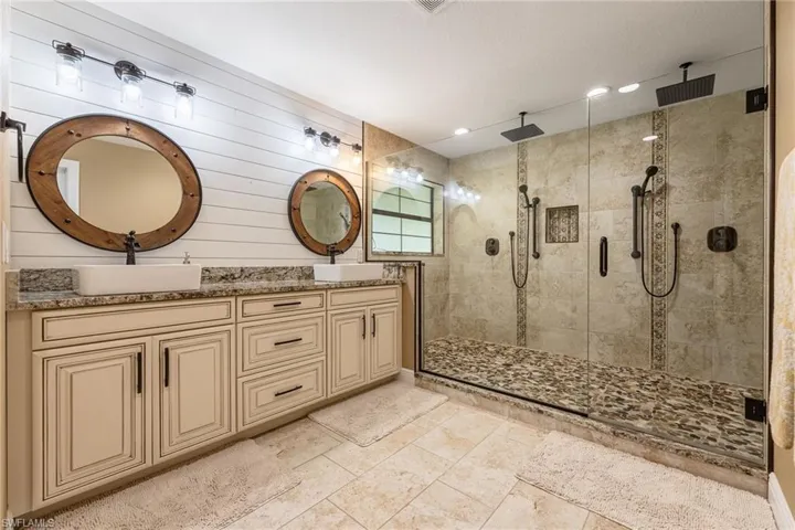 Bathroom featuring double vanity, a stall shower, and recessed lighting