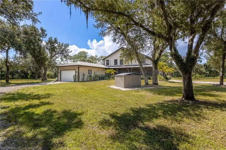 View of front facade featuring gravel driveway, an attached garage, and a front lawn