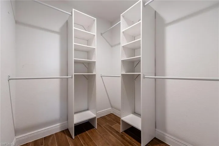 Walk in closet featuring dark wood-type flooring