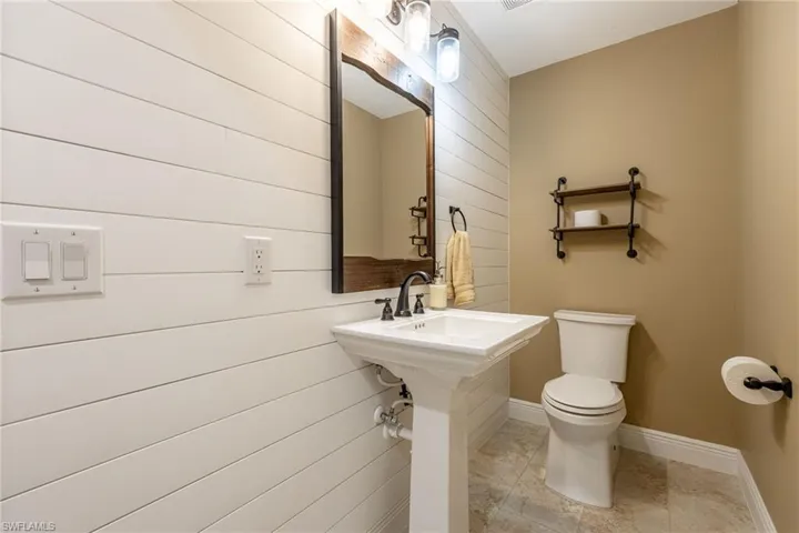 Bathroom with wooden walls and light tile patterned flooring