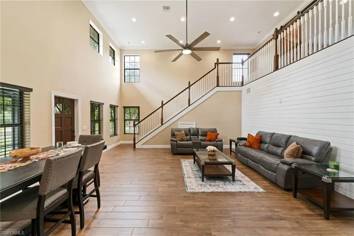 Living area featuring crown molding, light wood finished floors, stairway, recessed lighting, and a ceiling fan