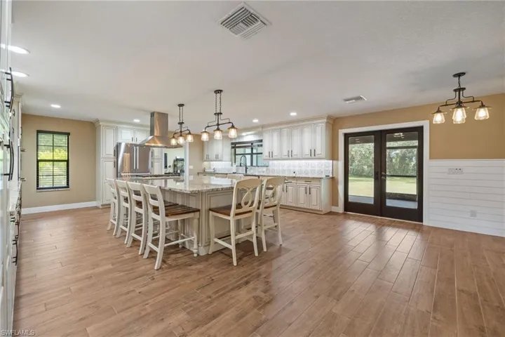 Dining space with light wood-style flooring, french doors, and a chandelier