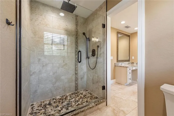 Full bathroom featuring vanity, a shower stall, and light tile patterned flooring