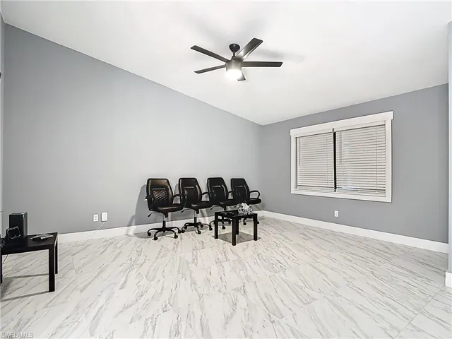 Office space with a ceiling fan and baseboards