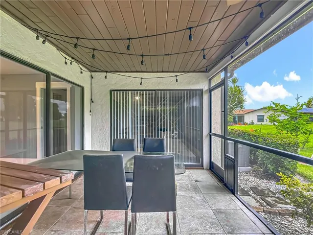 Sunroom / solarium with outdoor dining space and rail lighting