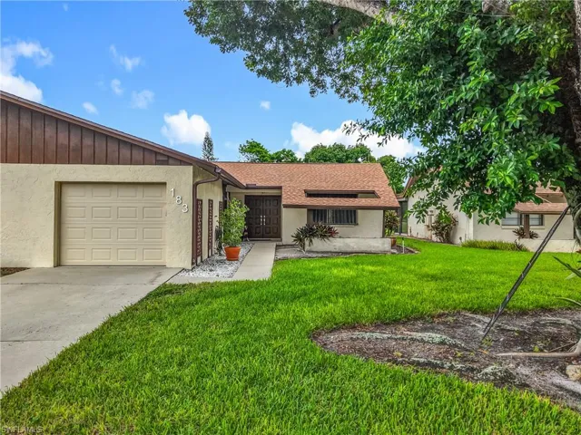 Ranch-style home with a front lawn, concrete driveway, stucco siding, and an attached garage