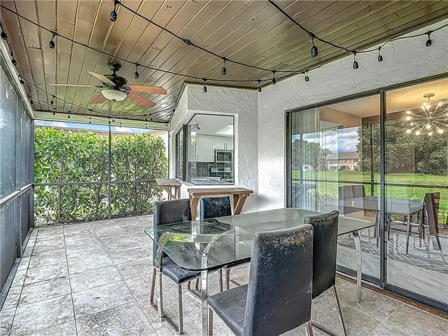 Sunroom / solarium featuring outdoor dining area, a ceiling fan, a chandelier, and track lighting