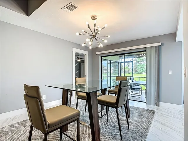 Dining area featuring light marble finish floors and a chandelier