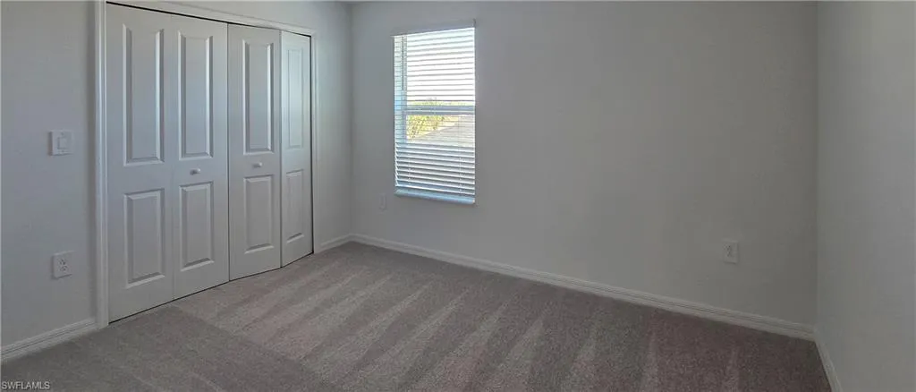 Unfurnished bedroom featuring carpet and a closet