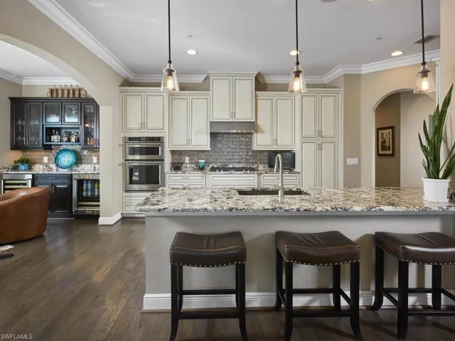 Kitchen with sink, light stone counters, and cream cabinetry