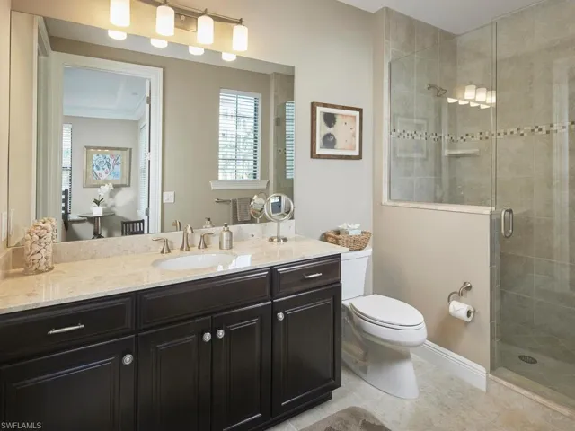 Bathroom featuring vanity, tile patterned flooring, toilet, and walk in shower