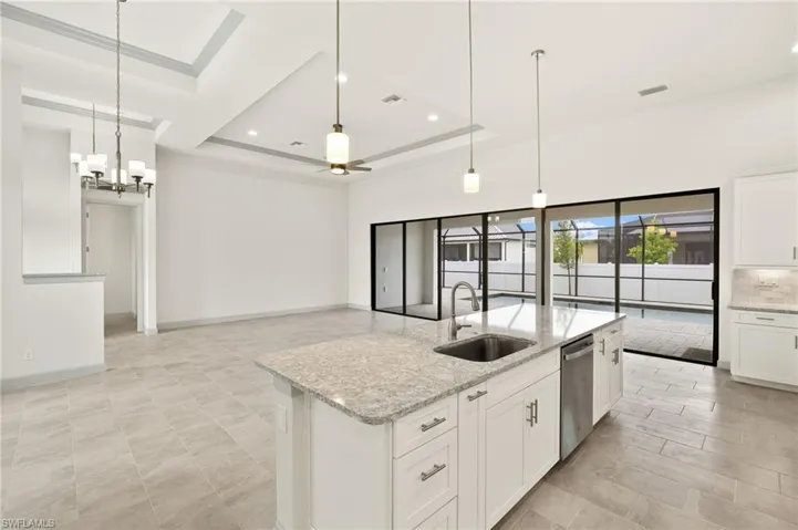 Kitchen with oversized quartz countertop with spice and cookie sheet cabinets included