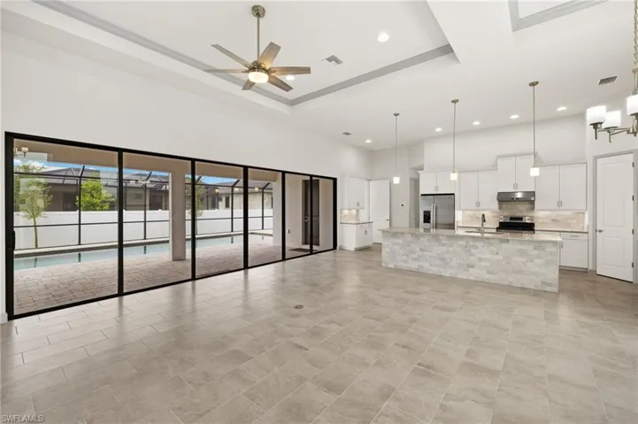 Great room view of kitchen and 24' sliding glass doors to pool and lanai