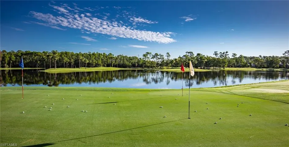 View of property's community featuring an area to practice putting, golf course view, and view of wooded area