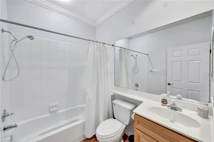 Full bathroom featuring shower / tub combo with curtain, vanity, and ornamental molding