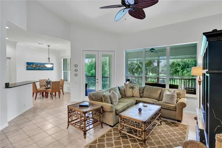 Living area featuring light tile patterned flooring, french doors, and ceiling fan