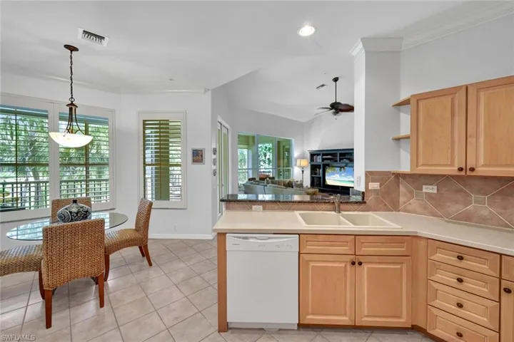 Kitchen featuring light brown cabinetry, white dishwasher, open floor plan, a peninsula, and recessed lighting