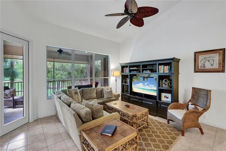 Living room featuring light tile patterned floors, high vaulted ceiling, a ceiling fan, and a sunroom