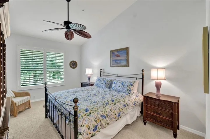 Bedroom with light carpet, high vaulted ceiling, and a ceiling fan