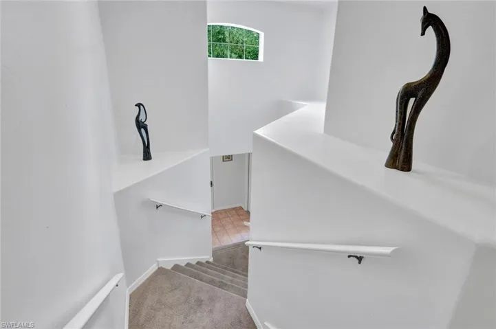 Stairway with carpet flooring and baseboards