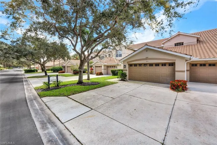 View of front facade featuring driveway, stucco siding, a residential view, a tiled roof, and a garage