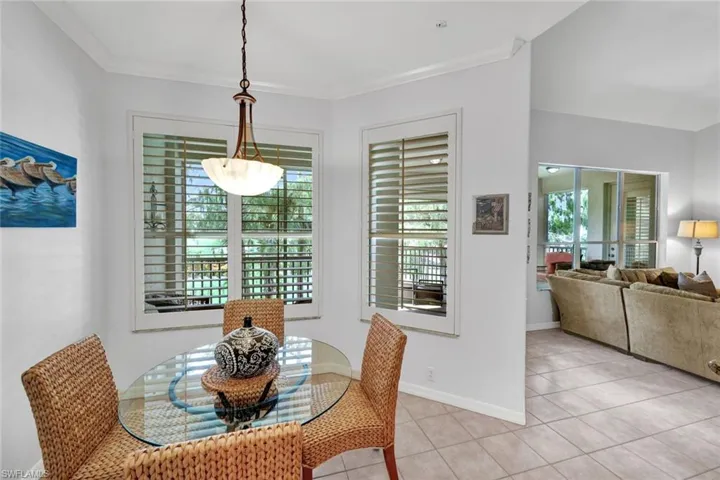 Dining space with light tile patterned flooring and ornamental molding