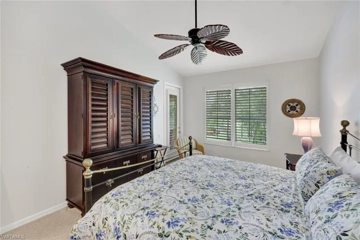 Carpeted bedroom with vaulted ceiling, access to exterior, and a ceiling fan