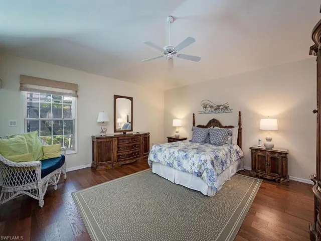 Spacious owners suite with dark hardwood / wood-style floors, walk in closet.