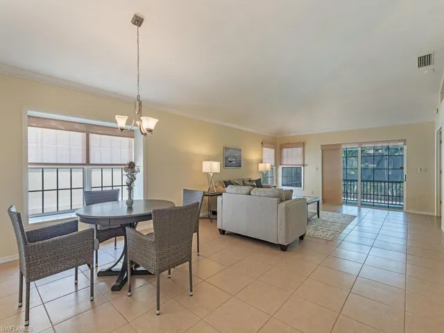 Tiled great room/dining area featuring crown molding and vaulted ceilings