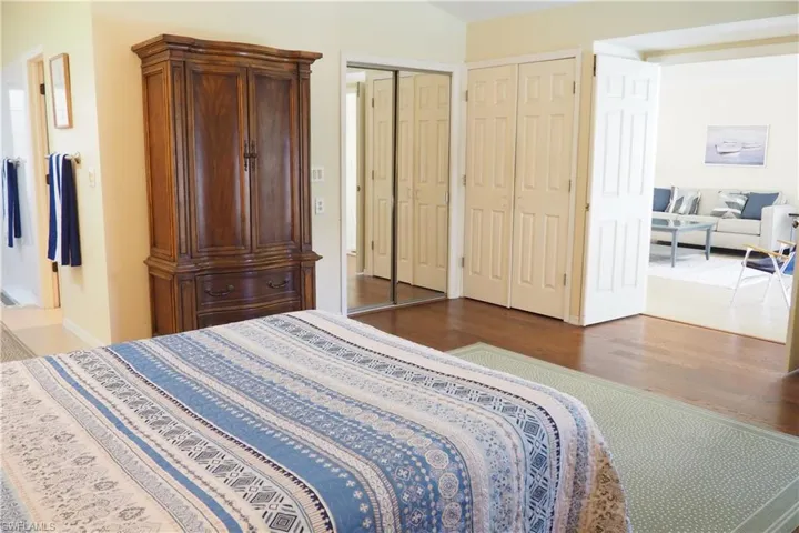Bedroom featuring dark hardwood / wood-style floors and multiple closets