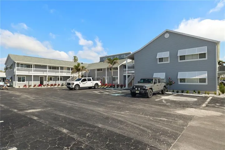 View of building exterior with uncovered parking