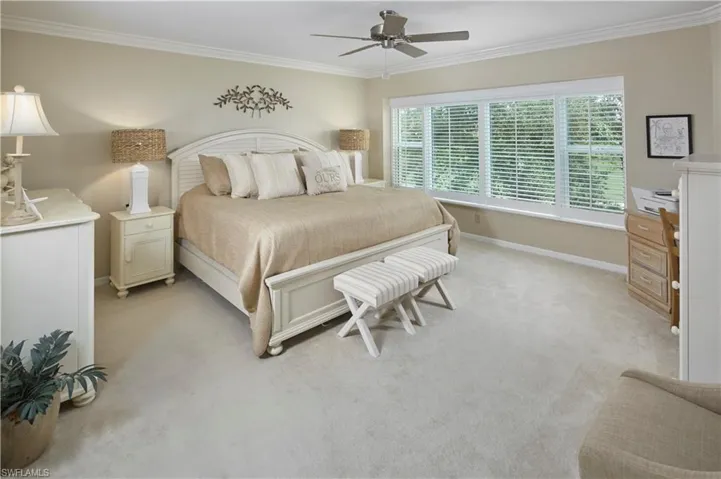 Large primary bedroom suite with expansive golf course view.