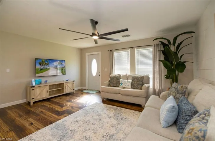 Living room featuring ceiling fan and dark hardwood / wood-style flooring