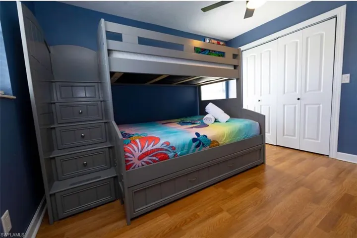Bedroom with ceiling fan, a closet, and light wood-type flooring