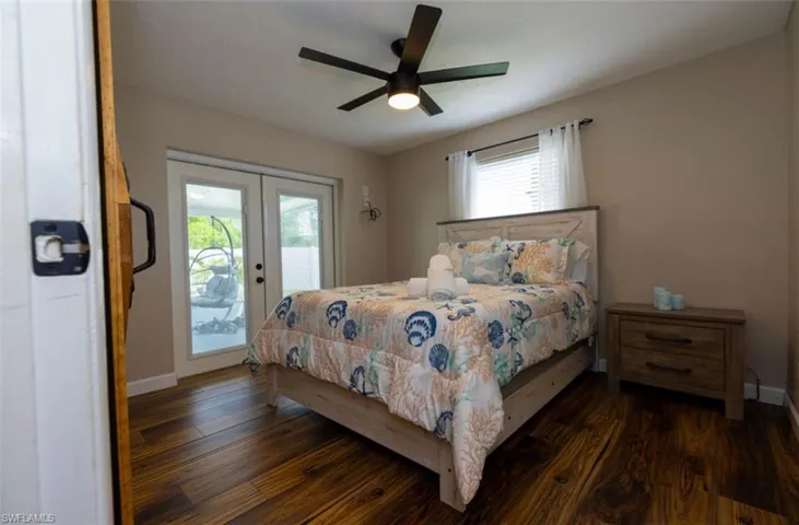 Bedroom featuring ceiling fan, dark hardwood / wood-style flooring, access to outside, and french doors