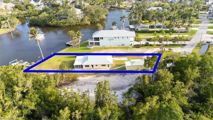 Aerial view of residential area featuring a nearby body of water and property boundaries highlighted-before demolition