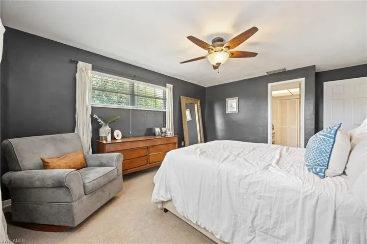 Bedroom with a ceiling fan, light carpet, and visible vents