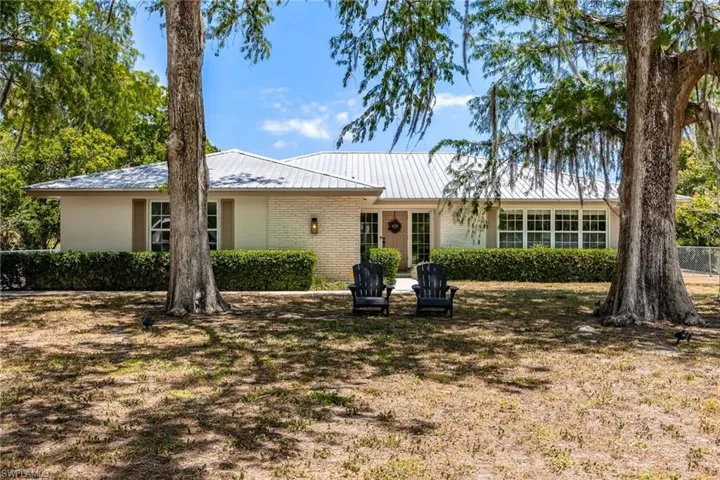 View of front of house with brick siding and metal roof