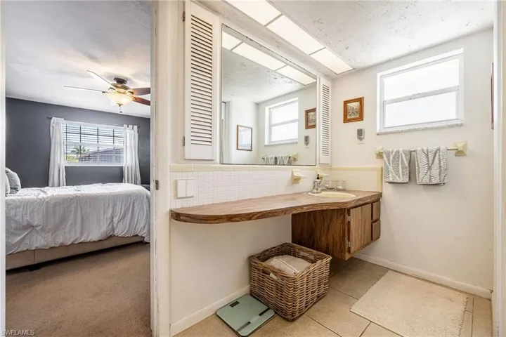 Ensuite bathroom featuring baseboards, ensuite bathroom, vanity, and tile patterned flooring