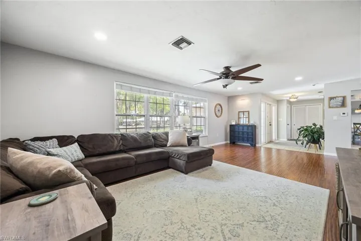 Living area featuring recessed lighting, baseboards, ceiling fan, visible vents, and wood finished floors