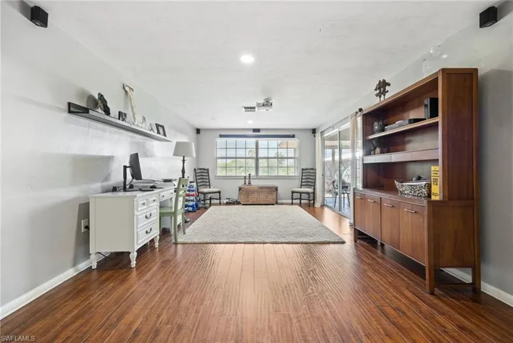 Living area featuring baseboards and dark wood-style floors