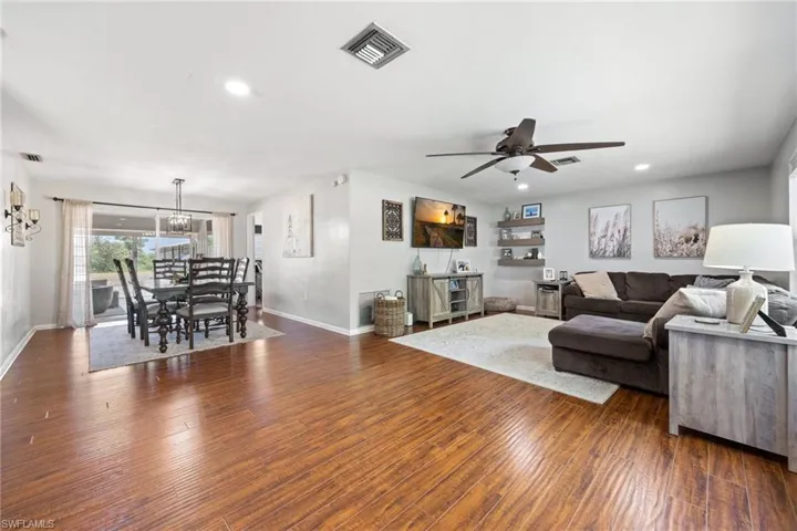 Living area featuring baseboards, recessed lighting, visible vents, and wood finished floors