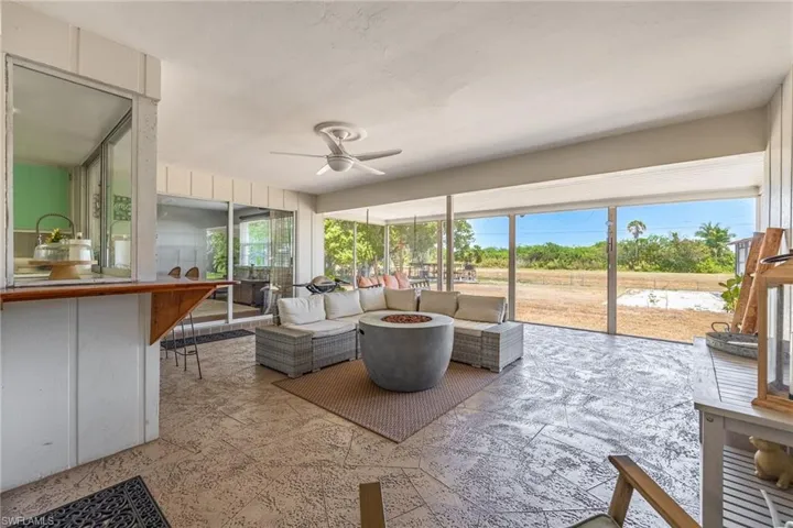Sunroom featuring an outdoor hangout area, ceiling fan, and outdoor dry bar