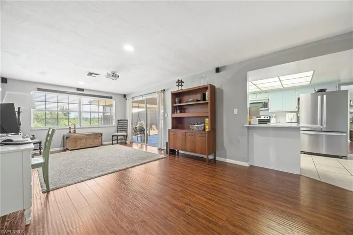 Living area featuring baseboards, light wood-style floors, and recessed lighting