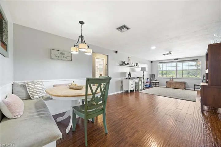 Dining space with an inviting chandelier, baseboards, dark wood-style floors, and visible vents