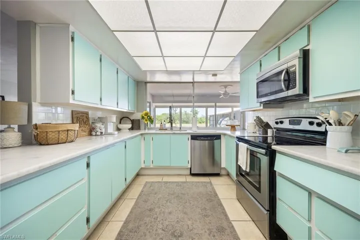Kitchen with light countertops, appliances with stainless steel finishes, tasteful backsplash, and light tile patterned floors