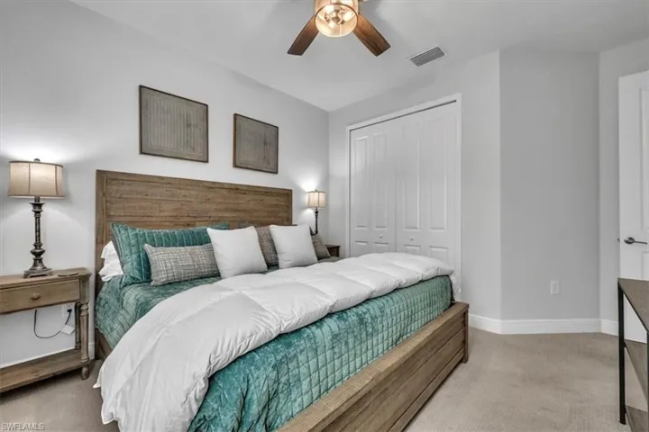 Bedroom featuring light carpet, a closet, and ceiling fan