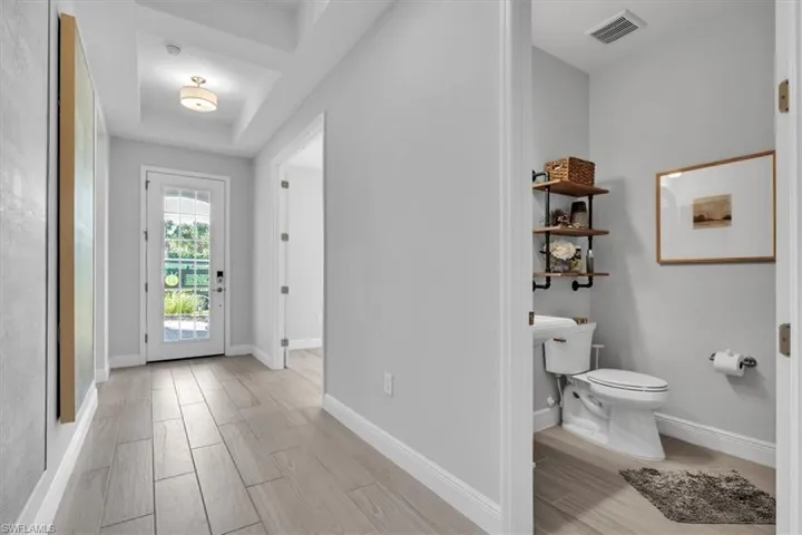 Entryway with wood finish floors and a raised ceiling
